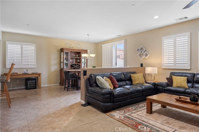 tiled living room with a notable chandelier