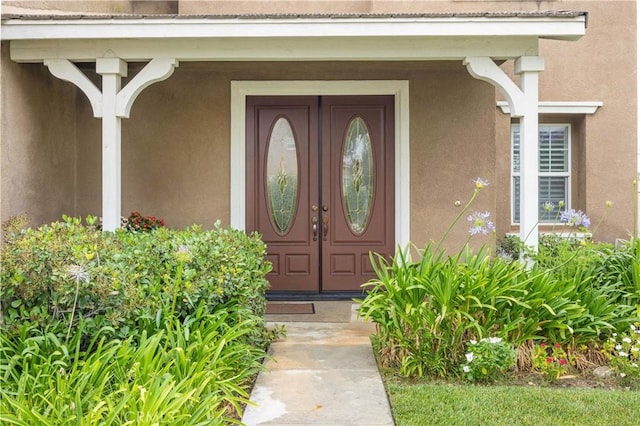 doorway to property featuring stucco siding