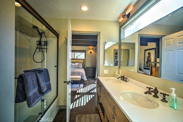 bathroom with a textured ceiling, vanity, shower / bath combination with glass door, and plenty of natural light