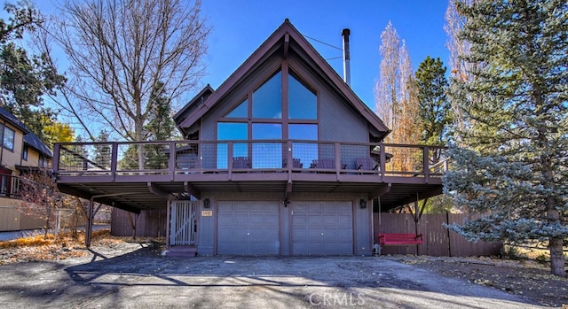 back of property featuring a garage and a wooden deck