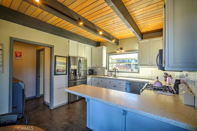 kitchen featuring beamed ceiling, white cabinets, kitchen peninsula, rail lighting, and stainless steel appliances