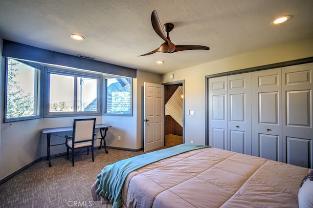 bedroom with a closet, ceiling fan, carpet flooring, and a textured ceiling