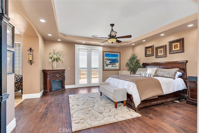 bedroom featuring ceiling fan, dark hardwood / wood-style floors, access to exterior, and french doors