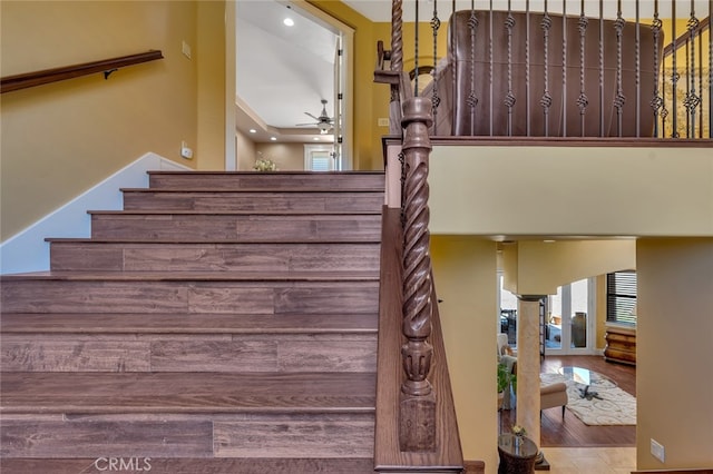 stairway with ceiling fan and hardwood / wood-style floors