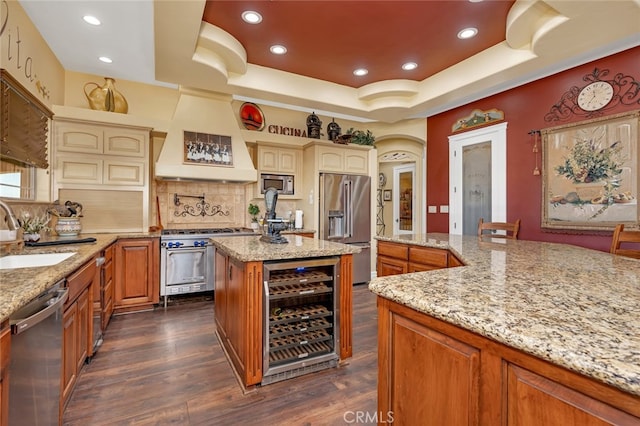 kitchen featuring wine cooler, a tray ceiling, high quality appliances, and backsplash