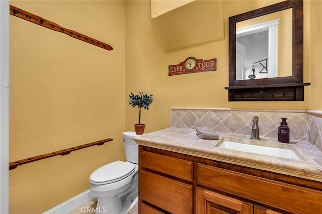 bathroom with vanity, backsplash, and toilet