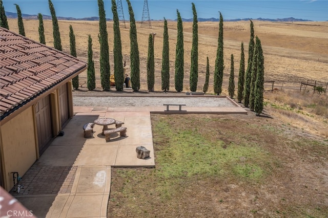 view of yard featuring a patio, a rural view, and a fire pit