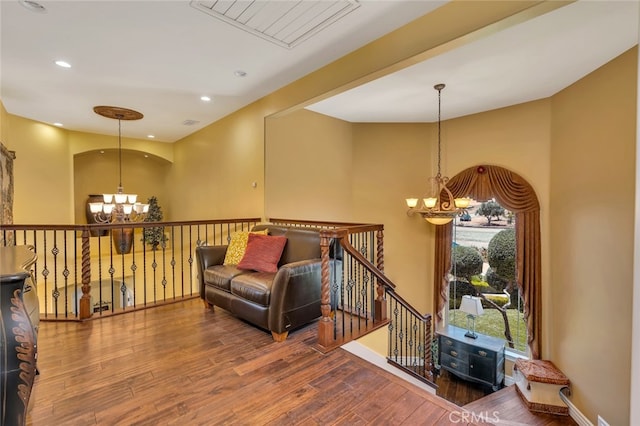 living area with wood-type flooring and an inviting chandelier