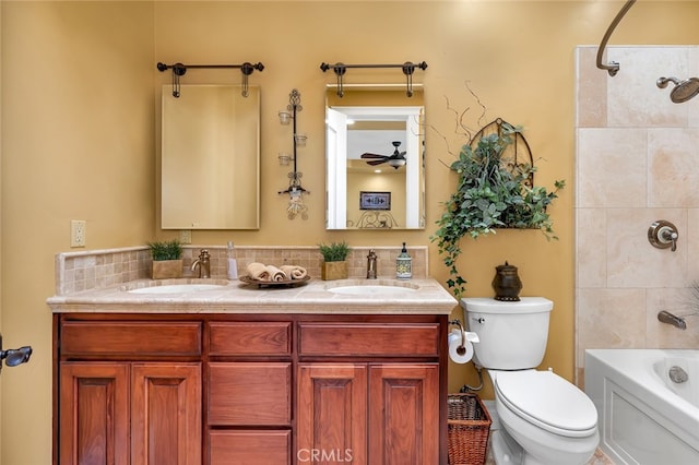 full bathroom featuring ceiling fan, tiled shower / bath combo, vanity, and toilet