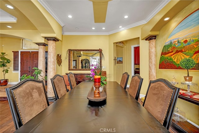 dining area featuring hardwood / wood-style floors, ornate columns, and crown molding