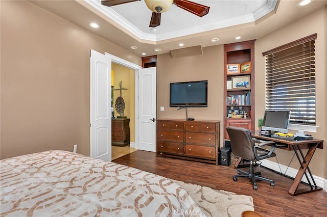 bedroom featuring a tray ceiling, ceiling fan, crown molding, and dark hardwood / wood-style flooring