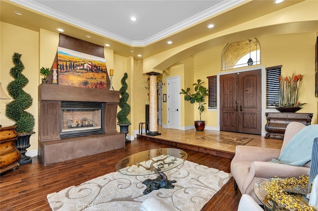 living room featuring ornamental molding, hardwood / wood-style floors, and ornate columns