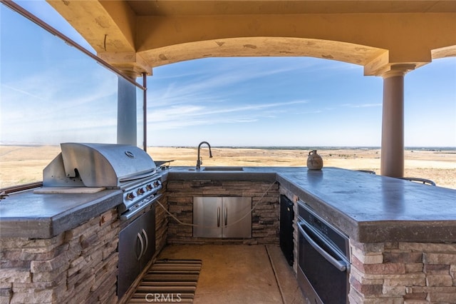 view of patio / terrace featuring area for grilling, sink, and an outdoor kitchen