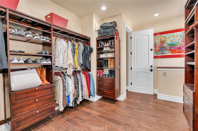 walk in closet with dark hardwood / wood-style floors