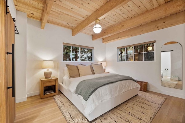 bedroom featuring light wood-type flooring, beam ceiling, a barn door, and wood ceiling