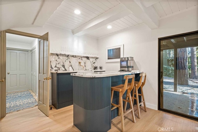 bar with beam ceiling, light hardwood / wood-style floors, and wooden ceiling