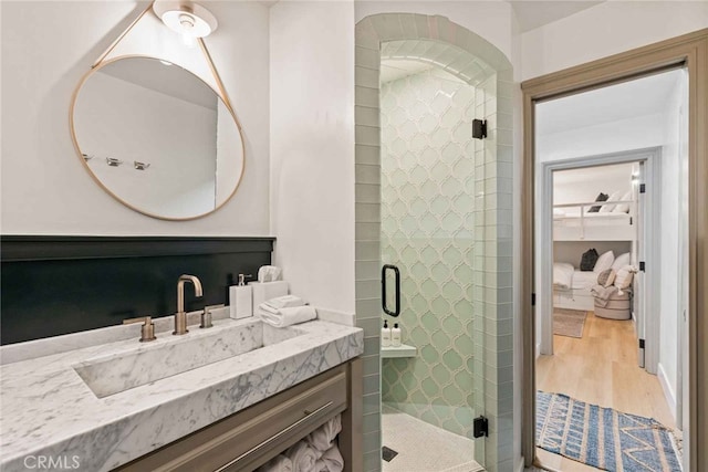 bathroom with wood-type flooring, walk in shower, and vanity