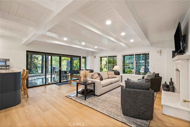 living room featuring lofted ceiling with beams, light wood-type flooring, wooden ceiling, and a fireplace