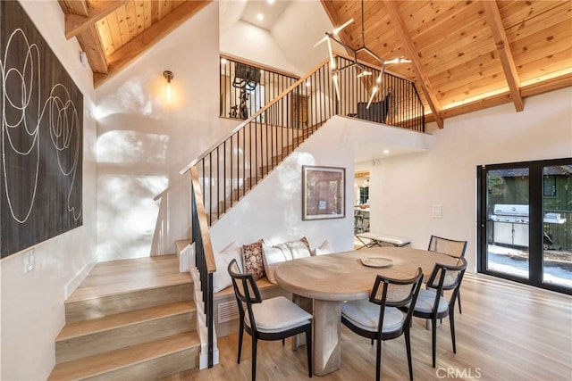 dining room featuring wooden ceiling, a healthy amount of sunlight, light hardwood / wood-style flooring, and high vaulted ceiling