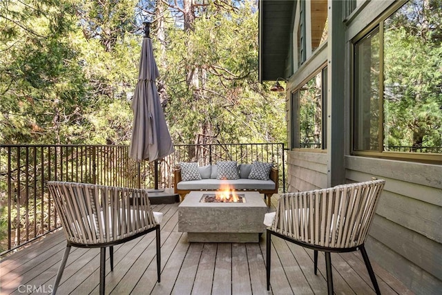 wooden terrace featuring an outdoor fire pit