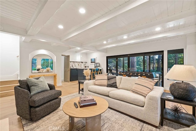 living room featuring beam ceiling and light hardwood / wood-style flooring