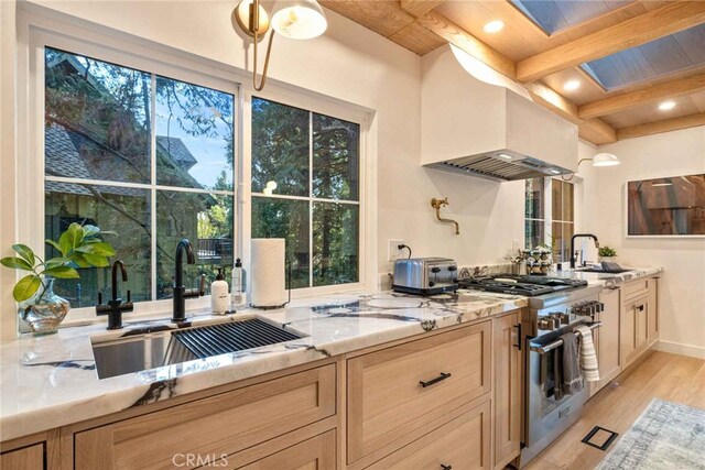 kitchen featuring sink, stainless steel stove, and light brown cabinets