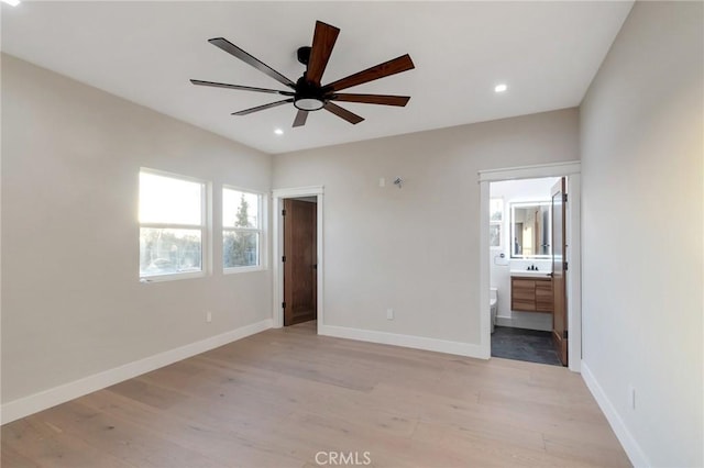 unfurnished bedroom featuring ensuite bath and light wood-type flooring