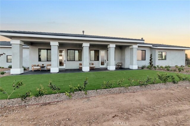 view of front of home with an outdoor hangout area, a lawn, and a patio area