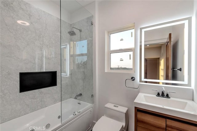 full bathroom featuring vanity, tiled shower / bath combo, and toilet