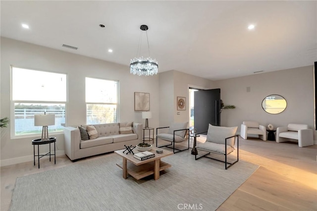 living room with a chandelier and light hardwood / wood-style floors