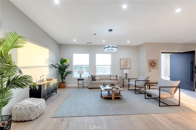 living room featuring an inviting chandelier and light hardwood / wood-style flooring