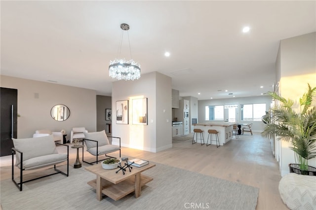 living room with a notable chandelier and light hardwood / wood-style floors