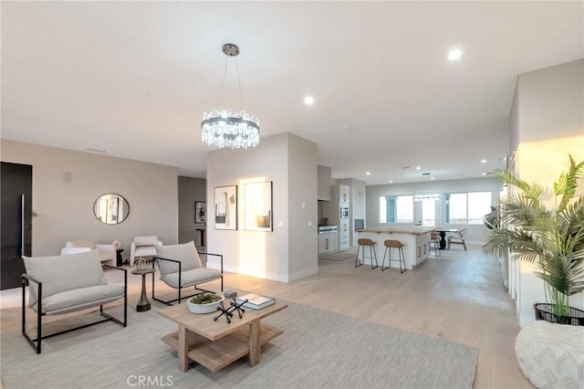 living room featuring a notable chandelier and light wood-type flooring