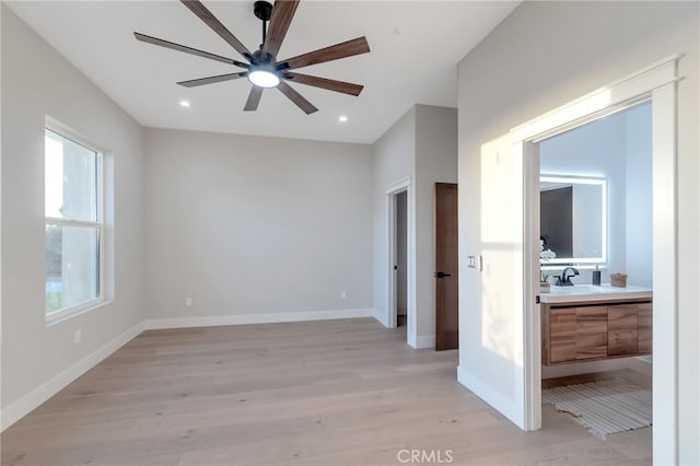 spare room with ceiling fan, light wood-type flooring, and sink