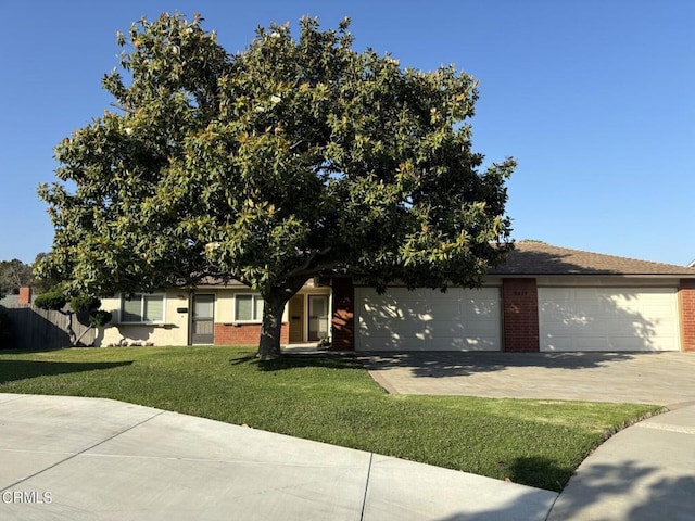 view of property hidden behind natural elements with a front yard and a garage