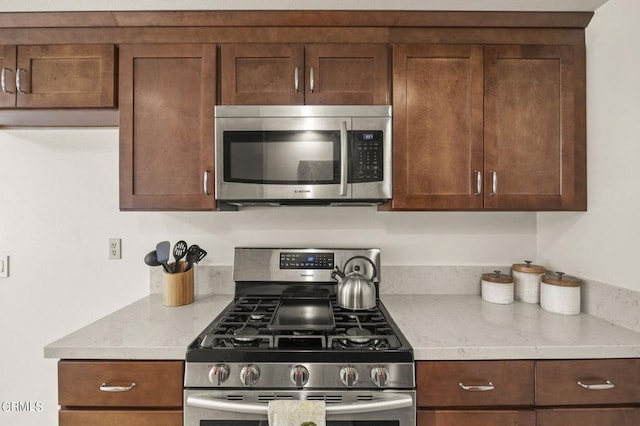 kitchen featuring appliances with stainless steel finishes and light stone countertops