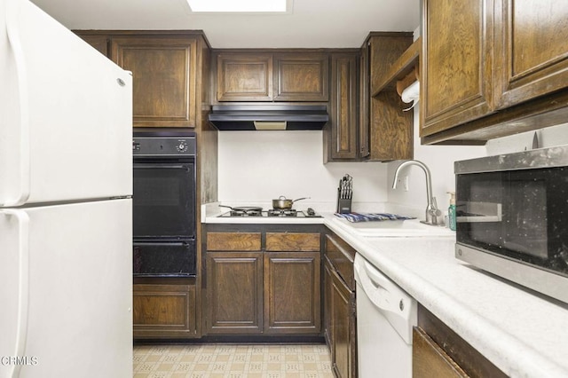 kitchen with sink, white appliances, and dark brown cabinetry