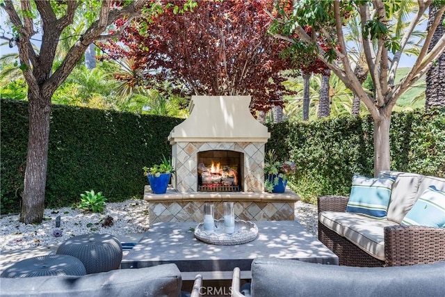 view of patio with an outdoor living space with a fireplace