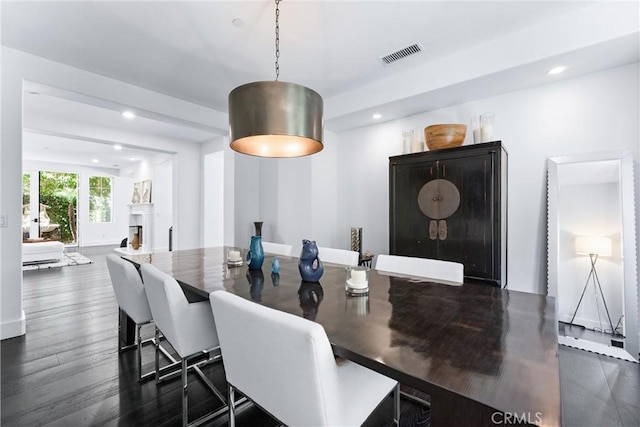 dining room with dark wood-style flooring, a fireplace, visible vents, and recessed lighting