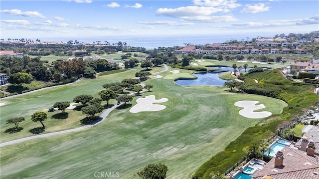 drone / aerial view with view of golf course and a water view