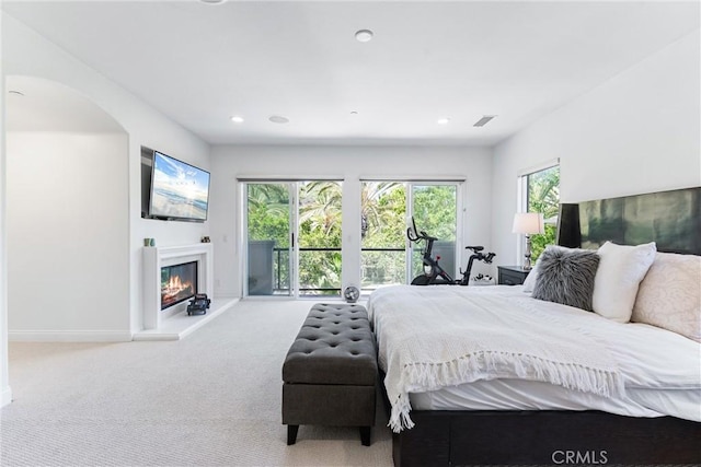 carpeted bedroom featuring access to exterior, recessed lighting, visible vents, a glass covered fireplace, and baseboards