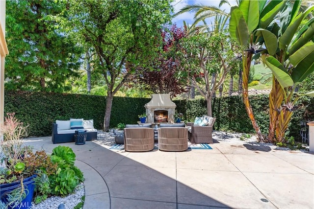 view of patio with an outdoor living space with a fireplace and a fenced backyard