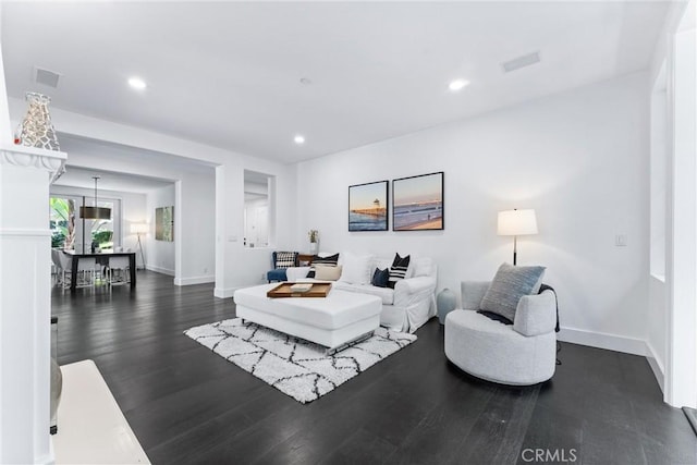 living area featuring baseboards, visible vents, dark wood finished floors, and recessed lighting