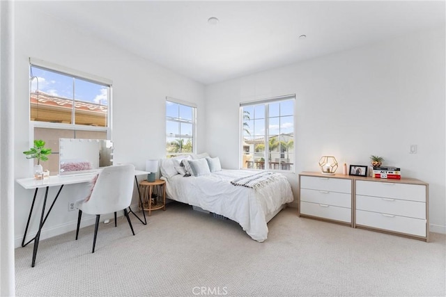 bedroom with light carpet and baseboards