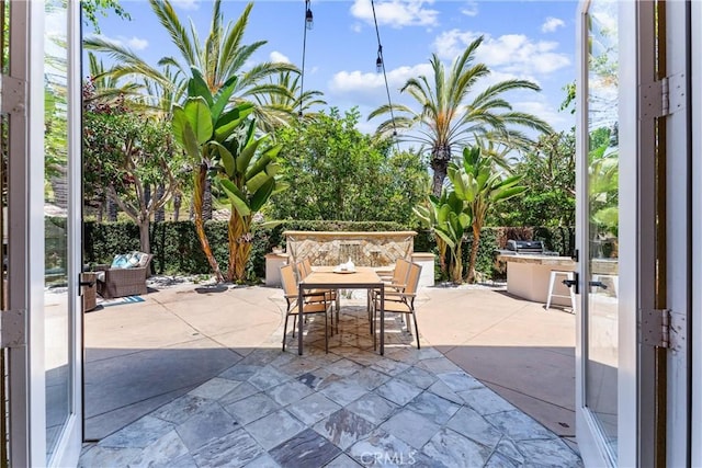 view of patio / terrace featuring fence, exterior kitchen, and outdoor dining space