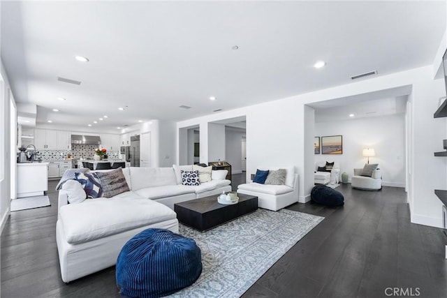 living area with dark wood-style floors, recessed lighting, visible vents, and baseboards