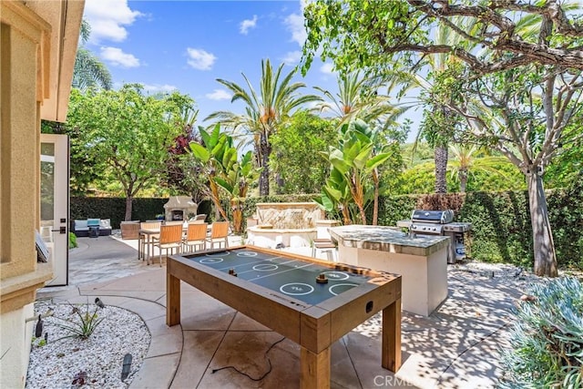 view of patio with exterior kitchen and fence