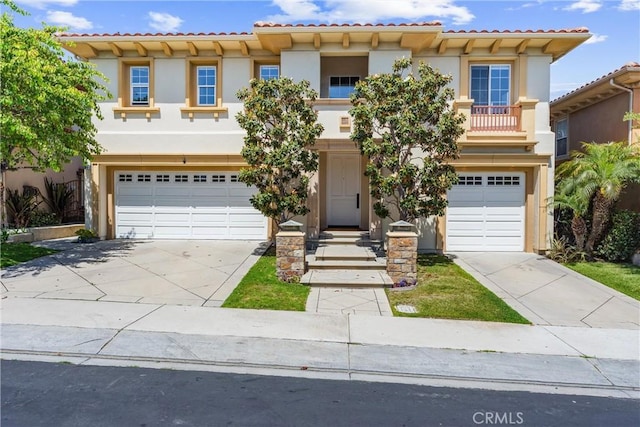 mediterranean / spanish home featuring a garage, concrete driveway, and stucco siding