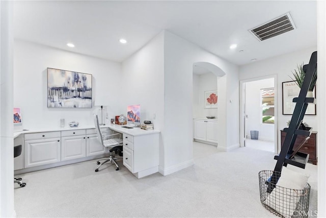 office space featuring light carpet, baseboards, visible vents, arched walkways, and recessed lighting