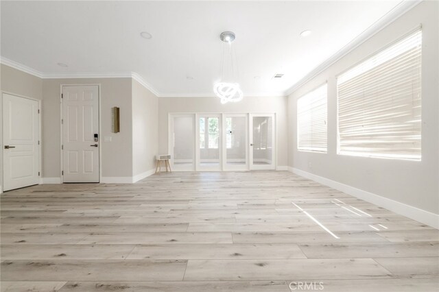 interior space featuring an inviting chandelier, crown molding, and light wood-type flooring